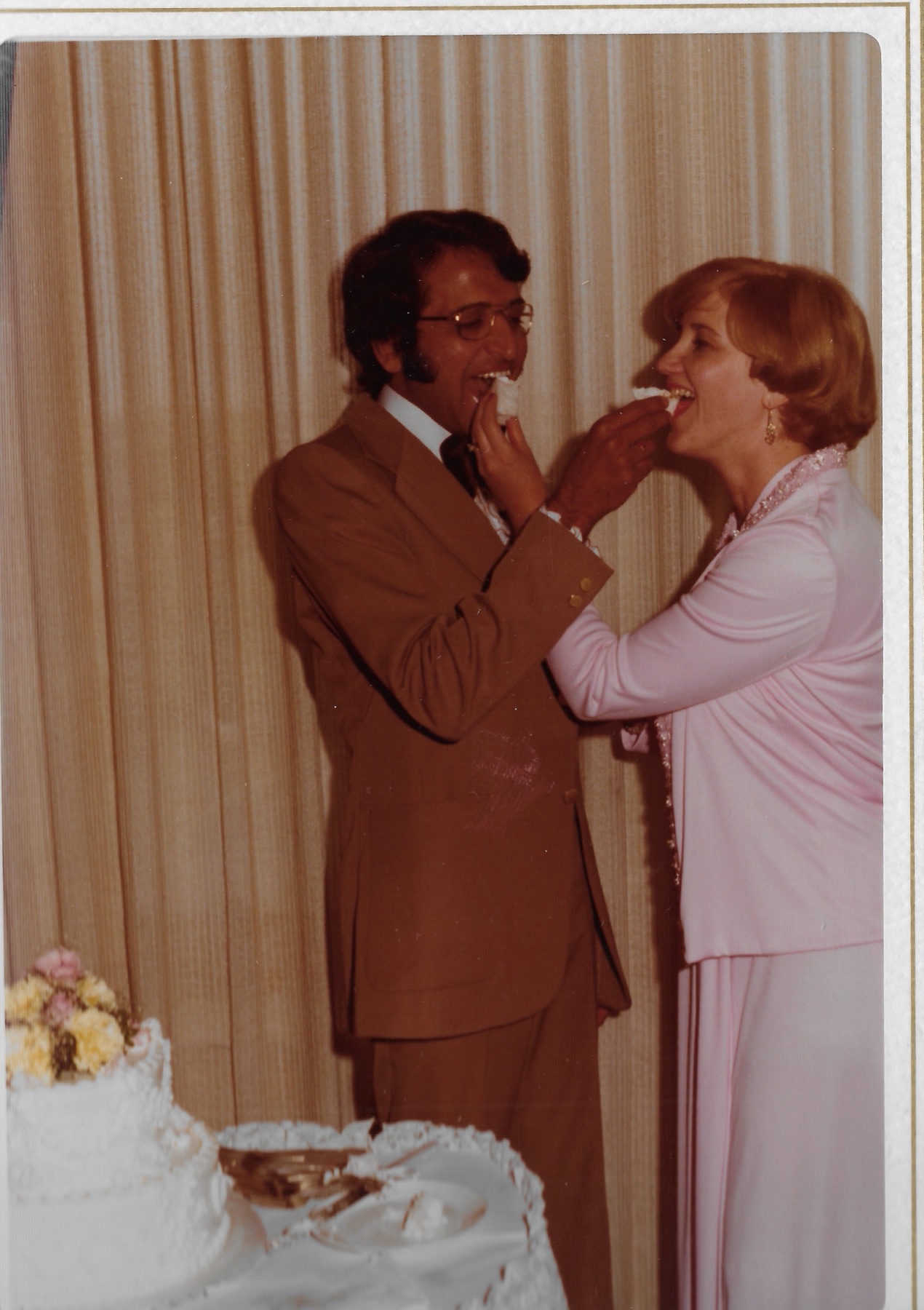 Feeding each other a bite of wedding cake
