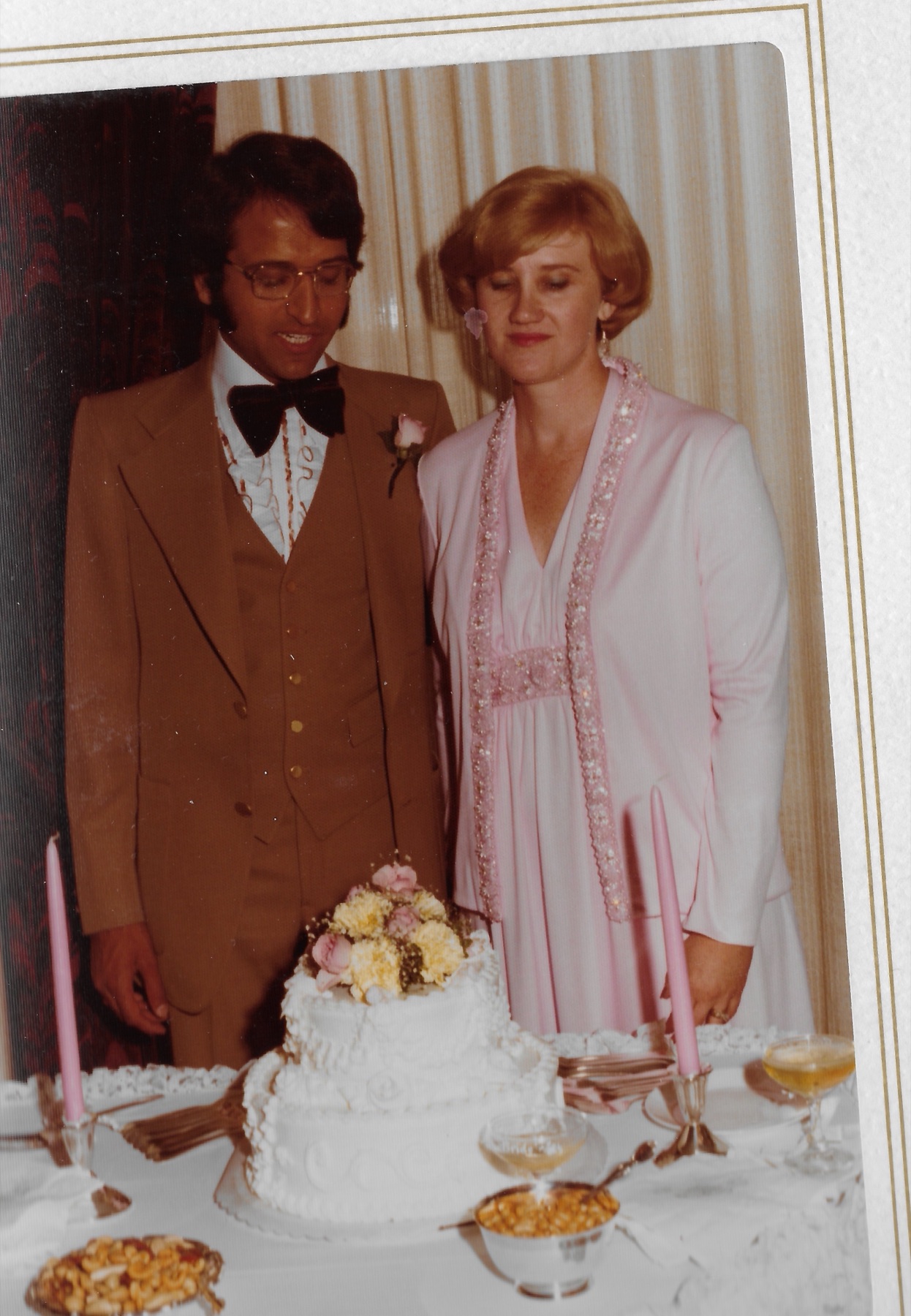 The two of them standing together behind the wedding cake