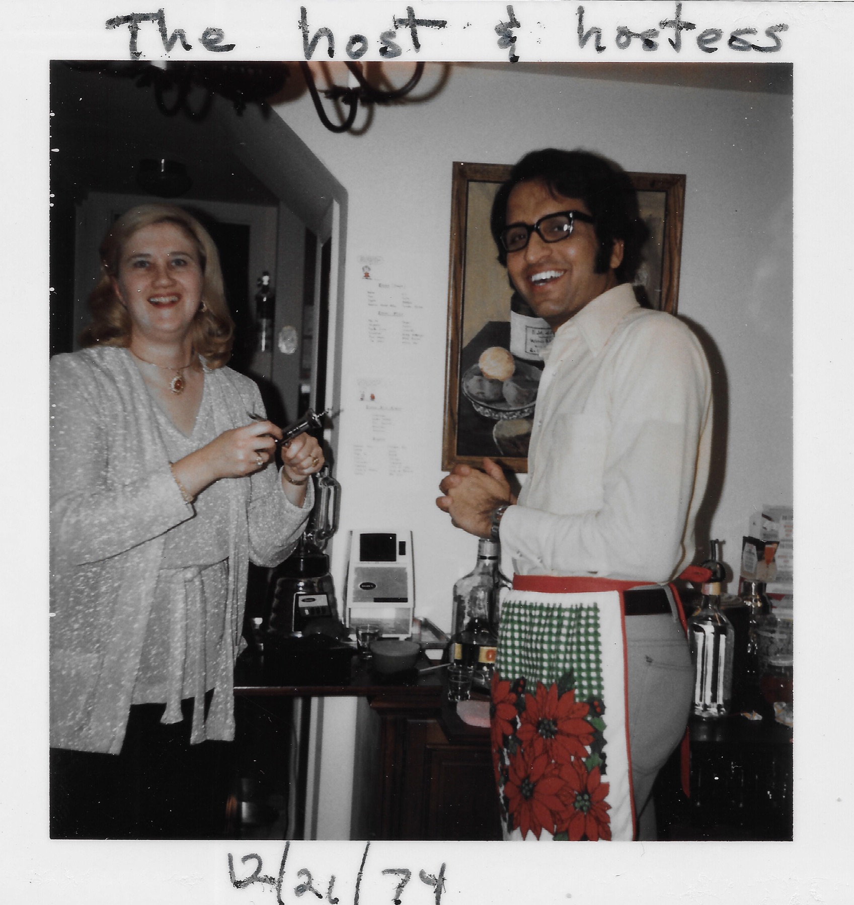 A black and white photo captioned in pen: The host & hostess, dated 12/26/74