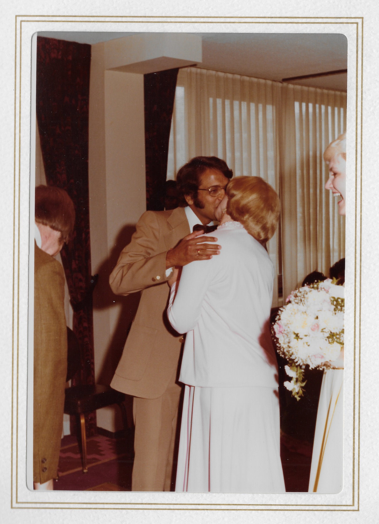 Madhu embracing and kissing a guest in the receiving line