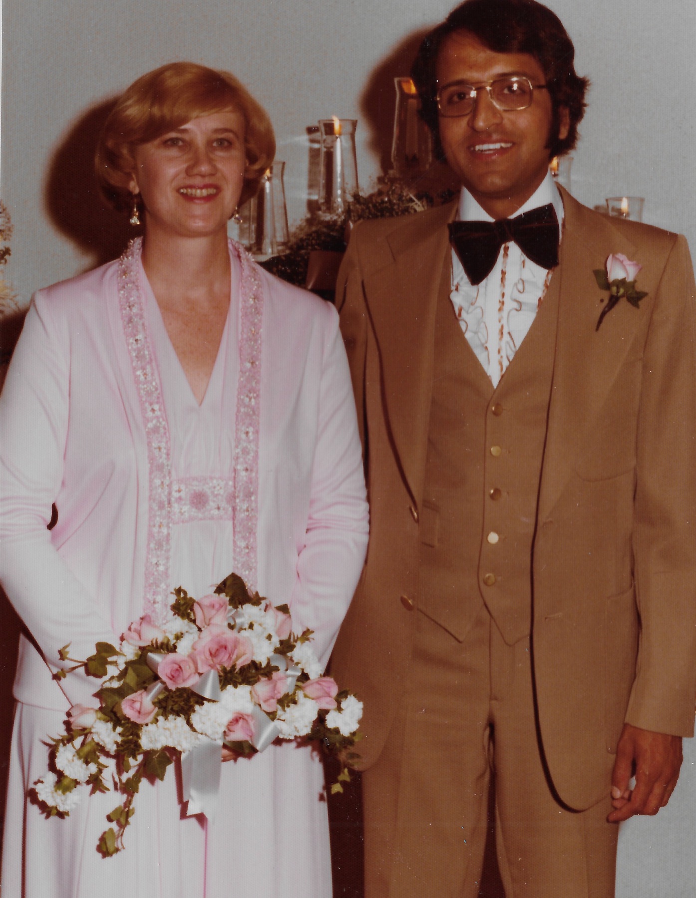 Mary Lee and Madhu posing together, she holding her bouquet