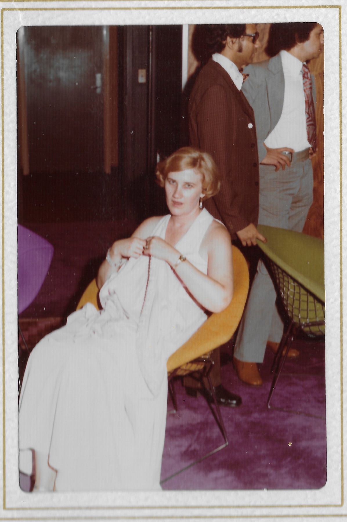 Mary Lee resting in a chair at the reception, dress gathered in her hands