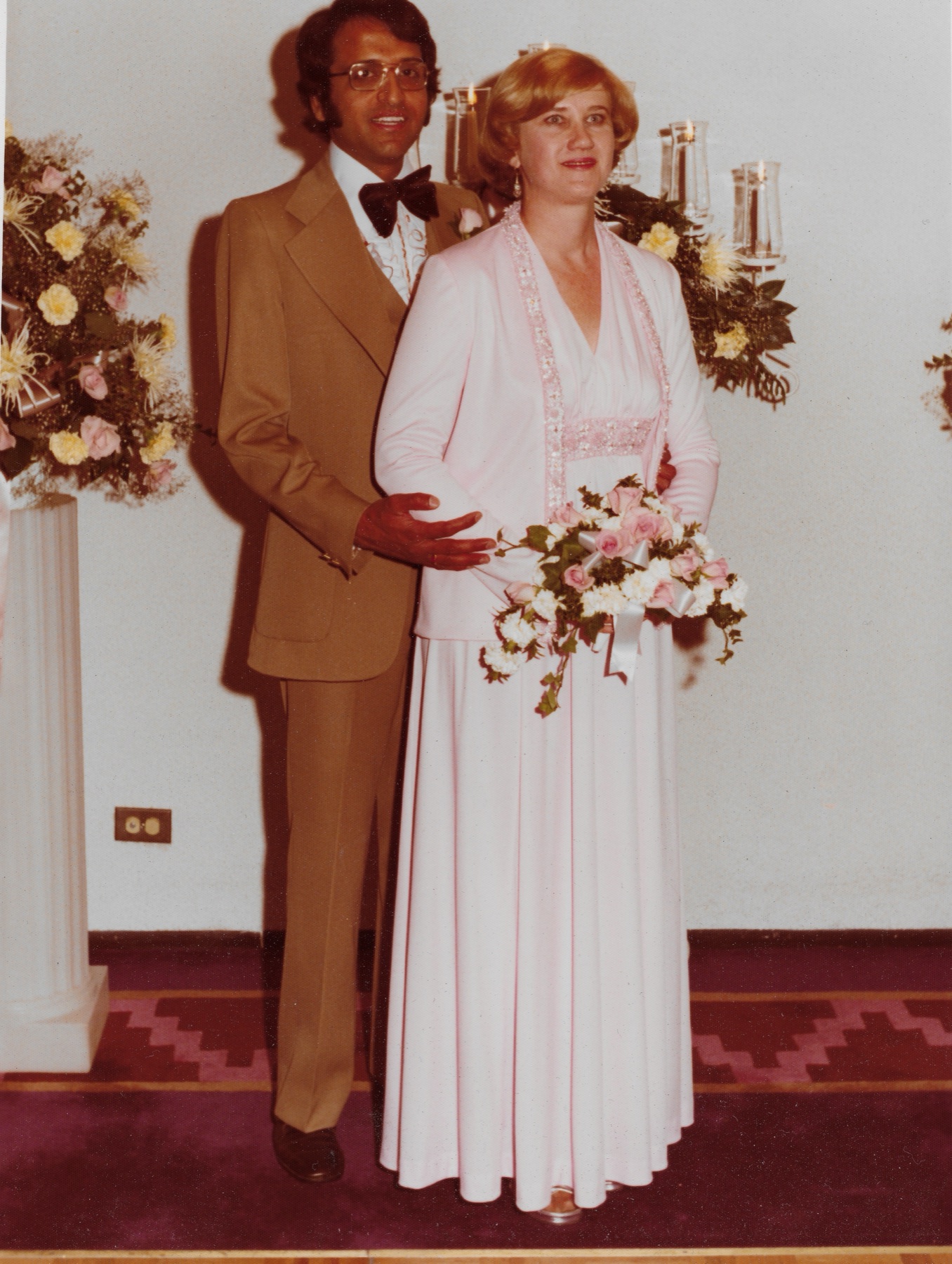 Mary Lee and Madhu at the altar, full length, with the bouquet